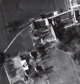 Luchtfoto uit 1993. In het midden de voormalige Proosdij met daarvoor een siertuin als overgang naar het open landschap. Rechts de kerk met daarachter de vervallen schuren en stallen. Links op de voorgrond de Pachthof met de ru�neuze grote schuur. Ook de vijvers als relicten van een vroeger grachtenstelsel werden vrijwel geheel gedempt. De formele terreinaanleg met den grooten weg in de middenas van de oostelijke pronkfa�ade verdween. Ten zuiden van deze axiale weg kwam een eenvoudige nieuwe weg die een directe ontsluiting betekende voor de diverse onderdelen van het complex. 